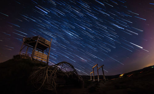 Low angle view of star trails against sky at night