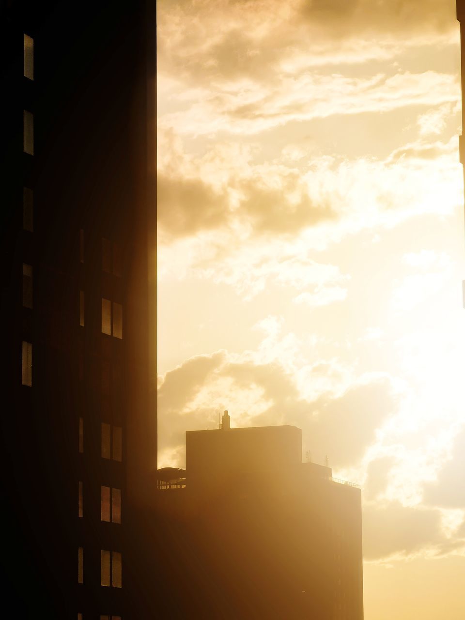 SILHOUETTE BUILDINGS AGAINST SKY DURING SUNSET IN CITY