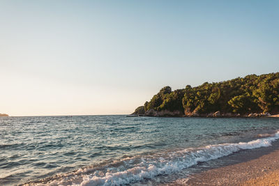 Scenic view of beach and sea against clear sky