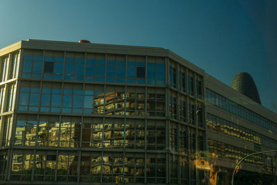 Low angle view of office building against clear sky