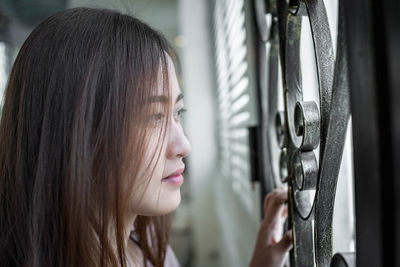 Close-up of woman looking through window