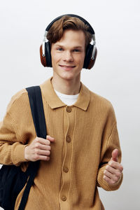 Portrait of young man standing against white background