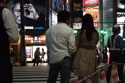 Rear view of people walking in city