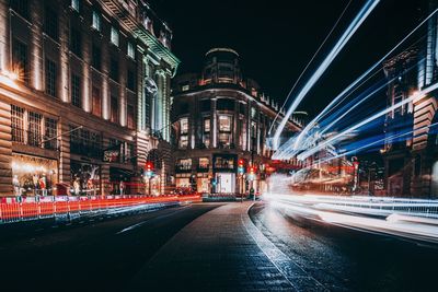 Illuminated city street and buildings at night