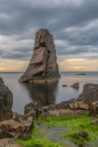 Scenic view of rocks in sea against sky during sunset