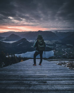 Man standing on mountain against sky during winter