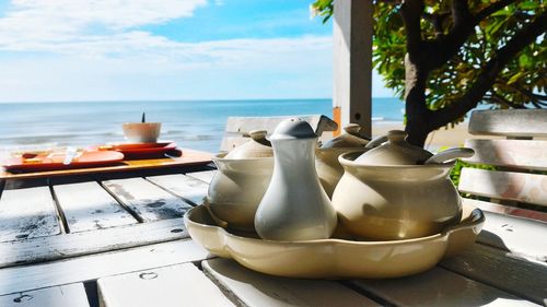 Close-up of drink on table by sea against sky