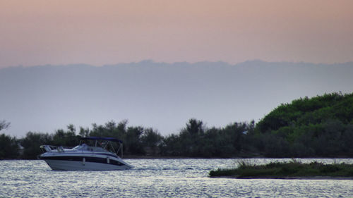 Boat sailing in lake against sky