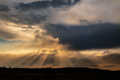 Scenic view of silhouette landscape against dramatic sky