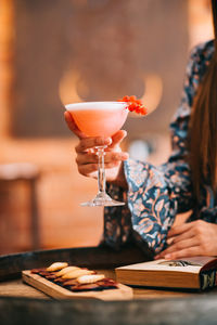 Glass of woman holding drink on table in restaurant