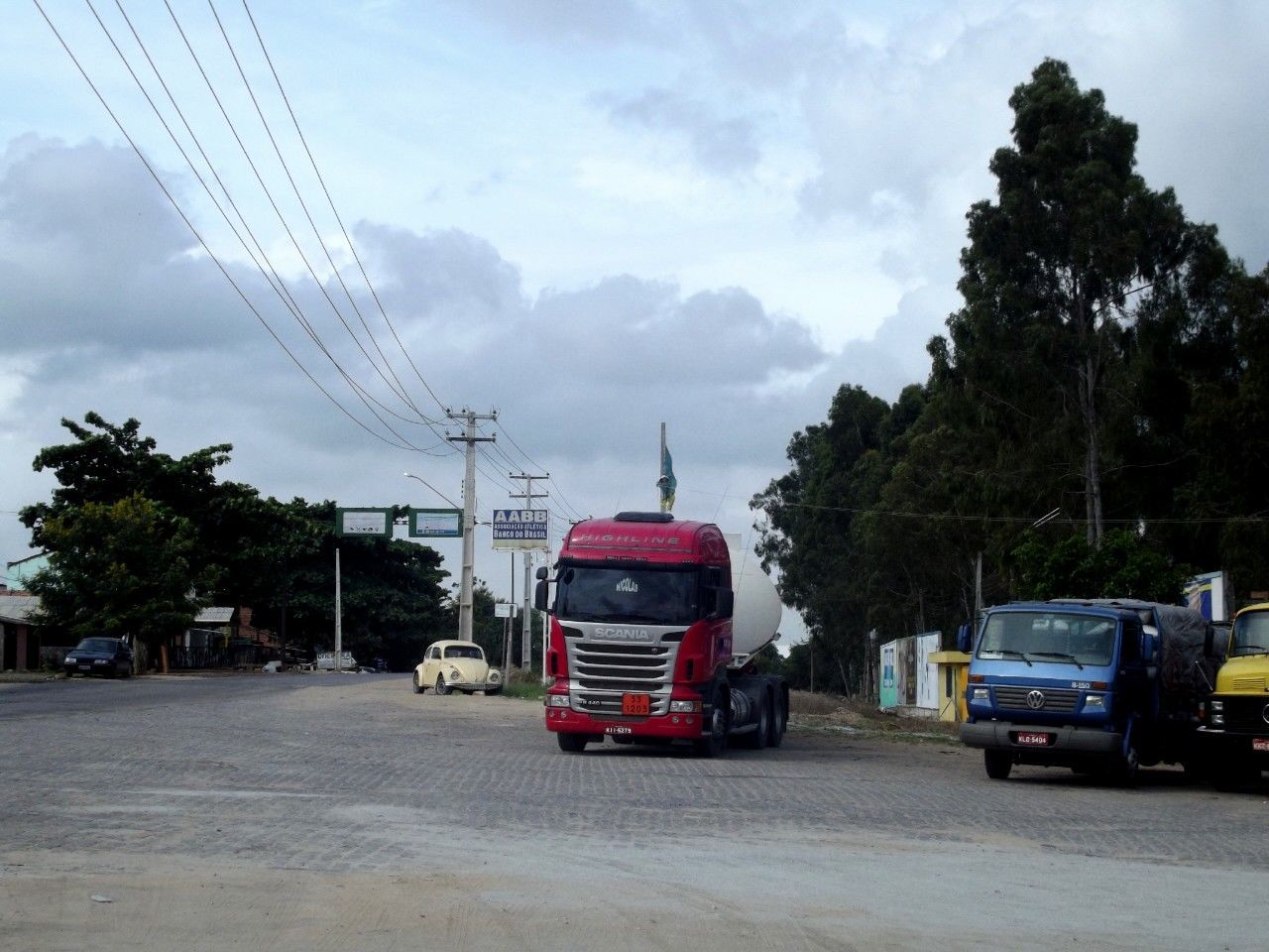 transportation, car, land vehicle, sky, mode of transport, tree, road, power line, street, electricity pylon, cloud - sky, building exterior, built structure, architecture, cloud, cable, cloudy, connection, power supply, on the move