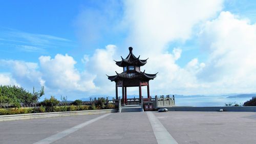 View of statue on road against cloudy sky