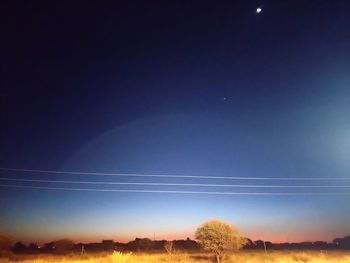 Low angle view of moon against clear blue sky