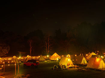 Illuminated tent on field against sky at night