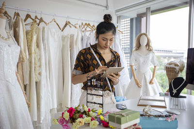 Fashion designer using digital tablet at boutique