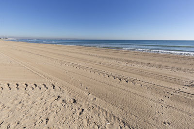 Scenic view of beach against clear blue sky