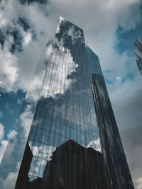 Low angle view of modern glass building against sky