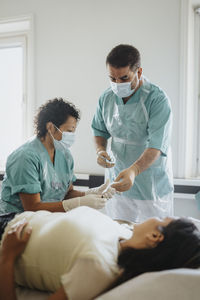 Male and female surgeons operating young woman in hospital