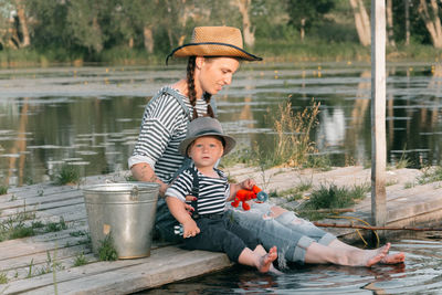 Young mother with a young son on the lake on a fishing trip.