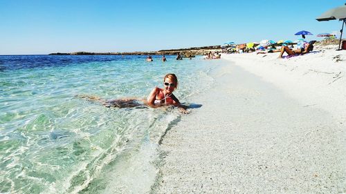 Woman on beach against clear sky