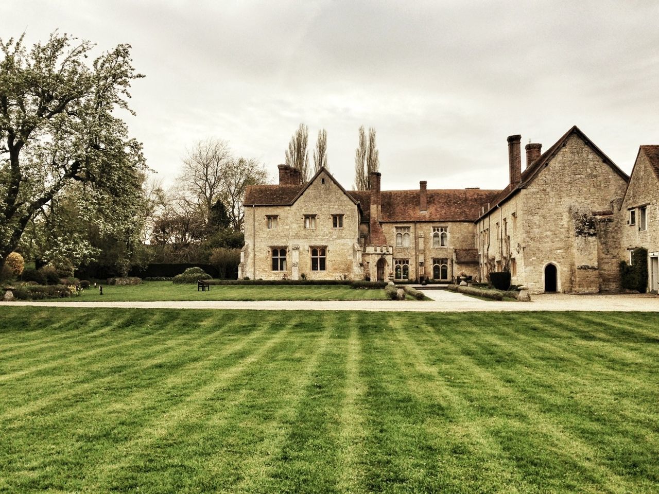 architecture, building exterior, built structure, grass, sky, tree, lawn, house, green color, cloud - sky, grassy, residential structure, day, cloud, field, growth, facade, outdoors, residential building, no people