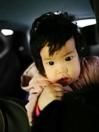 Portrait of cute baby girl in car