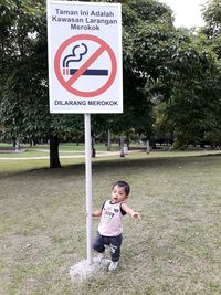 Full length of girl standing on grass against trees