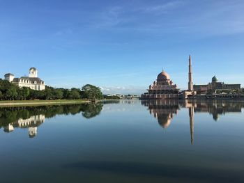 Reflection of putra mosque in lake against sky in city