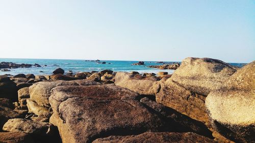 Panoramic view of rocks on beach against clear sky