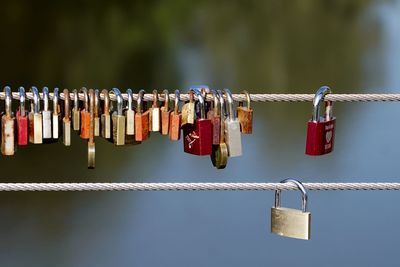 Close-up of love padlocks hanging on steel cable fence