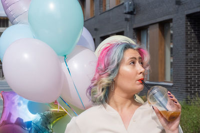 Portrait of woman with pink balloon