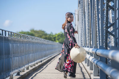 Beautiful woman walking over truong tien bridge in hue / vietnam