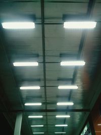 Low angle view of illuminated lights on ceiling of building