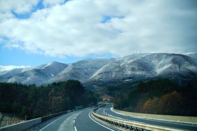 Road by mountain against sky