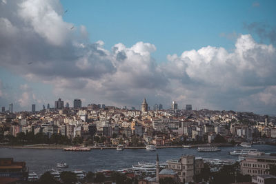 Buildings in city against cloudy sky