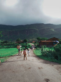 Rear view of people on mountain against sky