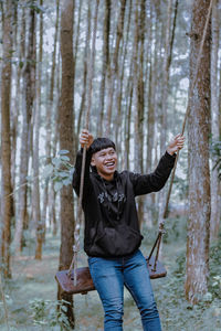 Portrait of young woman standing in forest