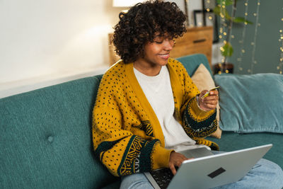 Side view of man using laptop while sitting at home