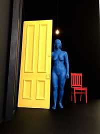 Rear view of man standing against yellow door