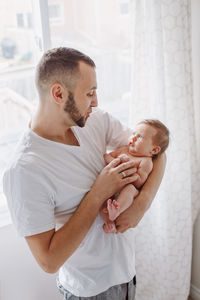 Man holding baby girl at home