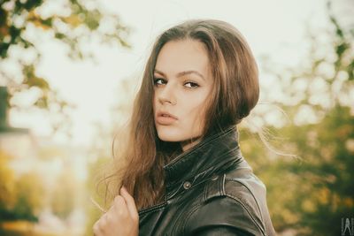 Portrait of beautiful woman against trees
