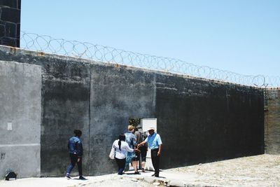 People walking against clear sky