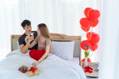 Young couple holding red flowers