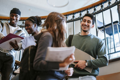 Rear view of woman using mobile phone while sitting at home