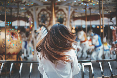 Rear view of woman with tousled hair at amusement park