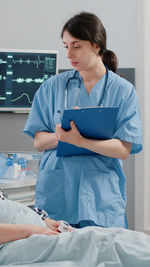 Portrait of doctor examining patient in hospital