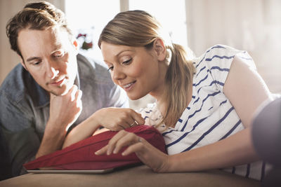 Mid adult couple using digital tablet in house