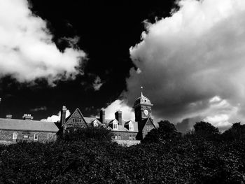 Low angle view of trees by historic building against sky