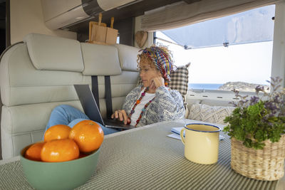 Side view of woman sitting on table