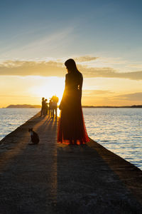 Rear view of couple on beach during sunset